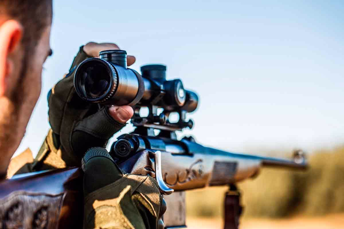 Un cazador disparando su rifle.
