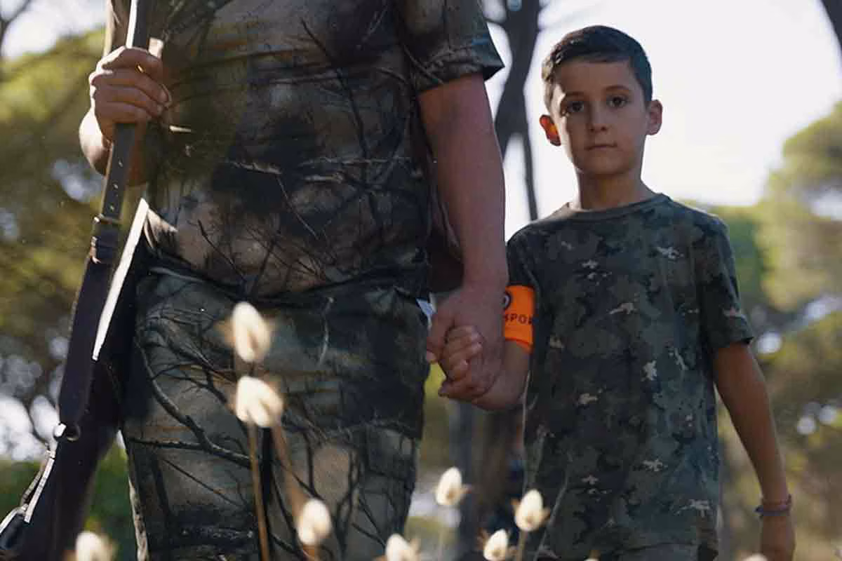 Un niño en compañía de su padre cazador.