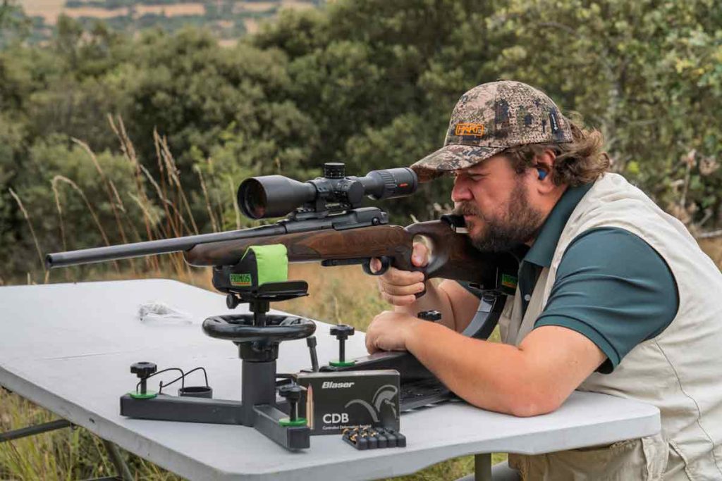 Un cazador poniendo un rifle a tiro.